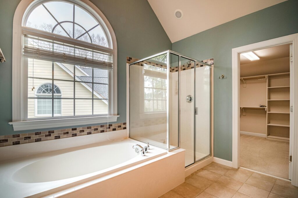Spacious contemporary bathroom featuring a luxurious bathtub, shower, and adjacent walk-in closet.